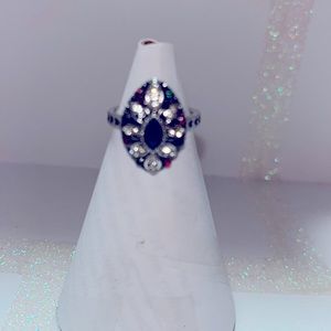 Bohemian style ring with emerald green stone. Heart cut out silver-toned band.